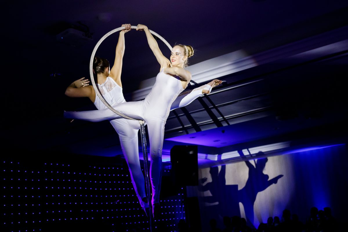 Akrobatické vystúpenie s kruhmi v bielych kostýmoch